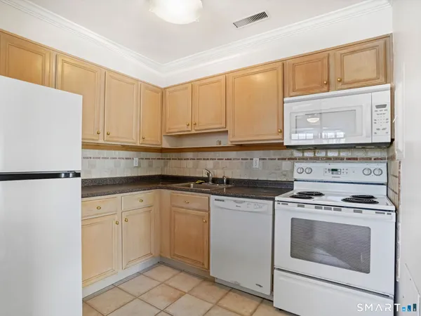 a kitchen with granite countertop cabinets stainless steel appliances and a sink