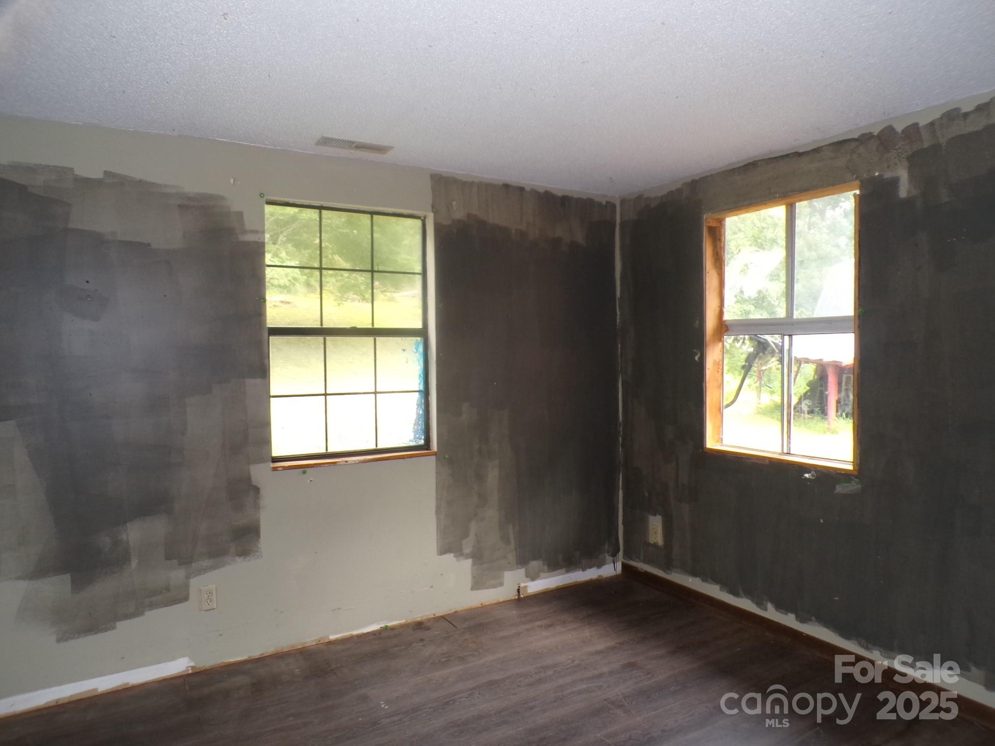 620 Hutch Mountain Road Fletcher, NC 28732 - Photo 12 of 22 an empty room with wooden floor and windows