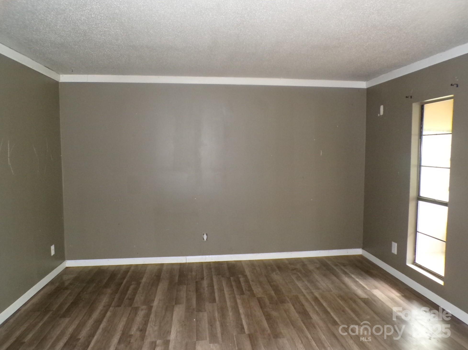 620 Hutch Mountain Road Fletcher, NC 28732 - Photo 13 of 22 a view of an empty room with wooden floor and a window