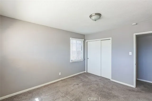 an empty room with windows and closet