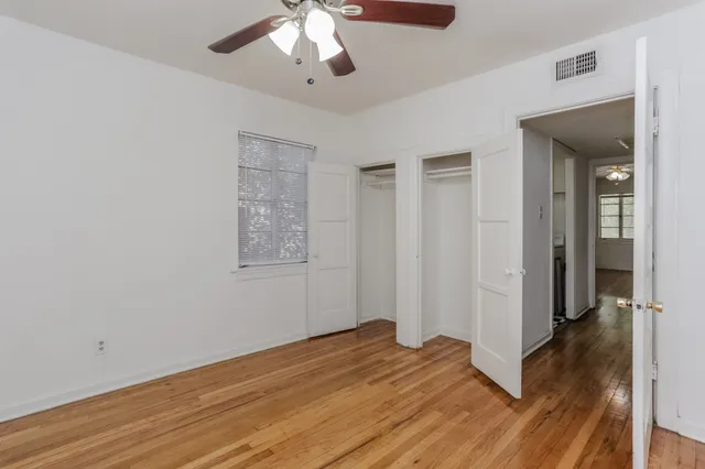 a view of empty room with wooden floor