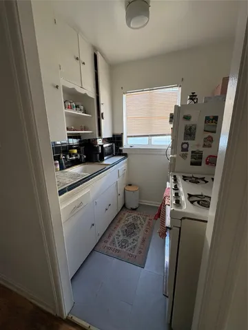 a kitchen with sink refrigerator and stove