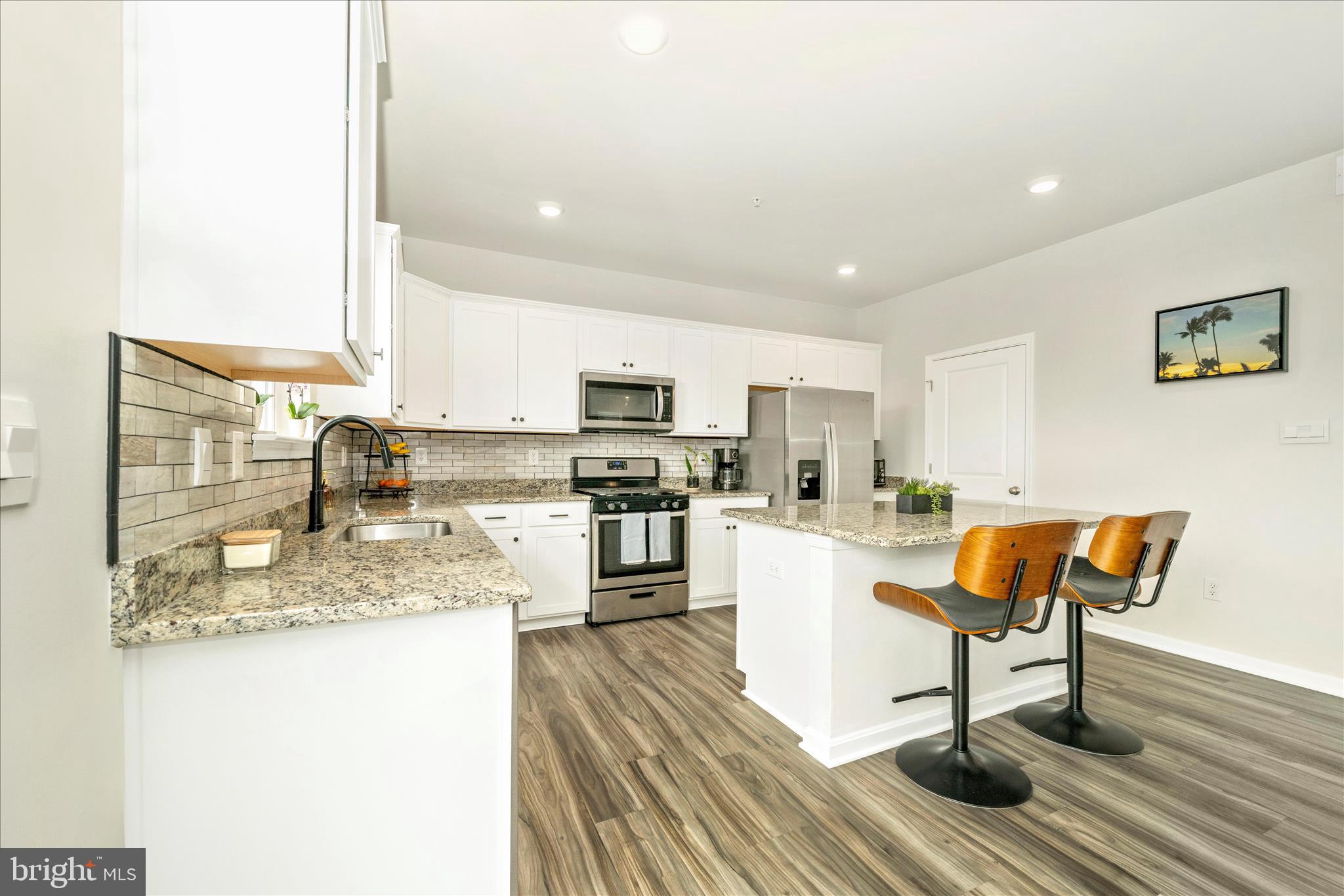 2086 Pomona Way Frederick, MD 21702 - Photo 5 of 77 a kitchen with stainless steel appliances granite countertop a stove top oven a sink dishwasher and white cabinets with wooden floor