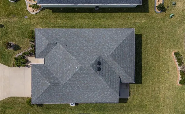 an aerial view of a house with a yard