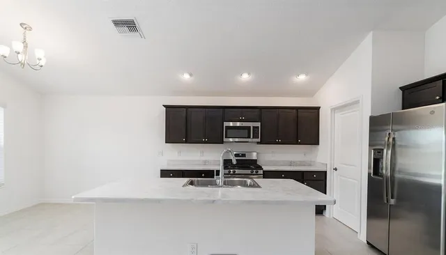 a kitchen with stainless steel appliances a refrigerator sink and microwave