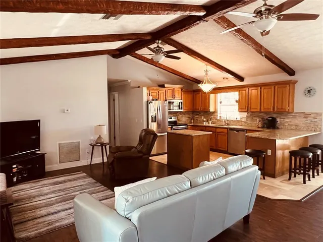 a kitchen with stainless steel appliances granite countertop sink stove microwave refrigerator and cabinets