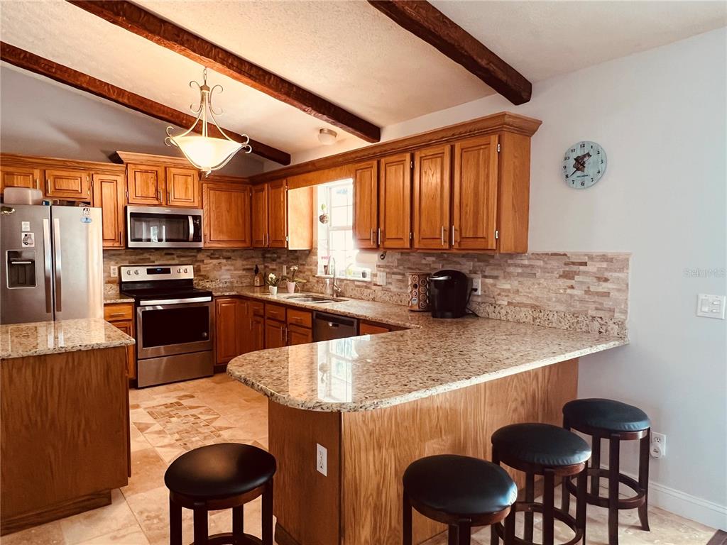 7961 West Riverbend Road Crystal River, FL 34428 - Photo 18 of 40 a kitchen with stainless steel appliances granite countertop a stove a sink a microwave and a refrigerator