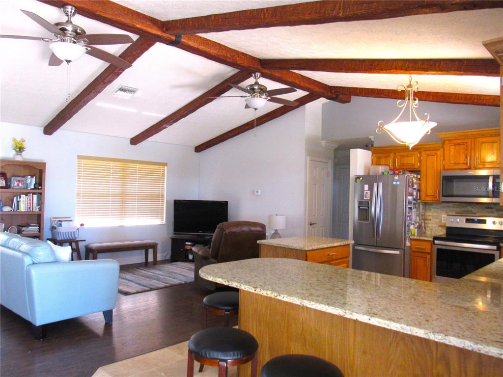 7961 West Riverbend Road Crystal River, FL 34428 - Photo 19 of 40 a kitchen with stainless steel appliances kitchen island granite countertop a refrigerator a stove and a sink with granite countertops