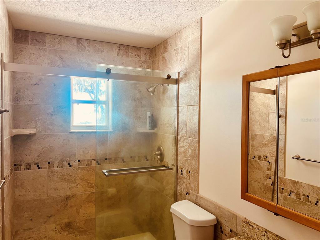 7961 West Riverbend Road Crystal River, FL 34428 - Photo 29 of 40 a bathroom with a granite countertop shower a toilet and a sink