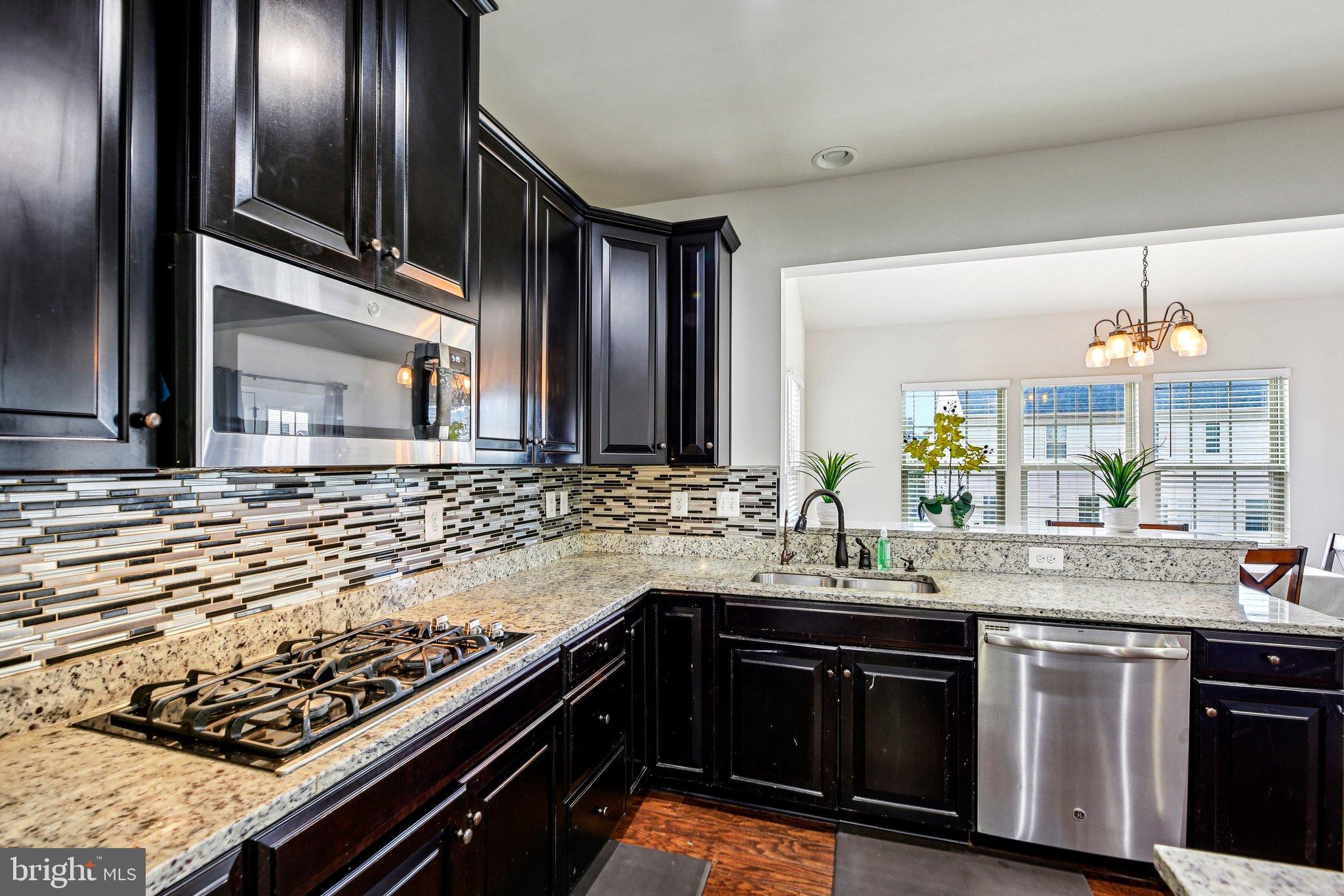 5940 Duvel Street Ijamsville, MD 21754 - Photo 18 of 62 a kitchen with kitchen island granite countertop stainless steel appliances and sink