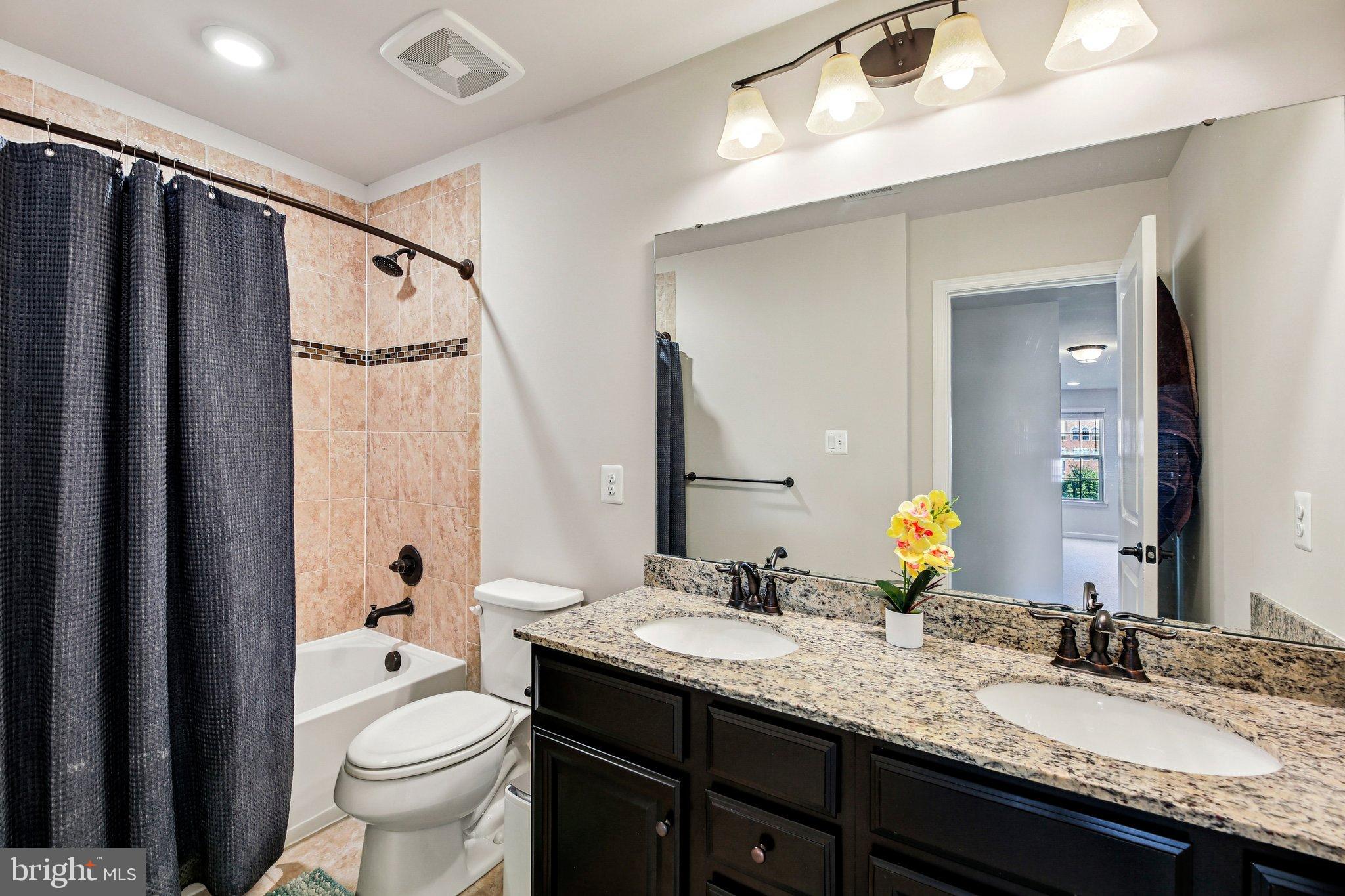 5940 Duvel Street Ijamsville, MD 21754 - Photo 32 of 62 a bathroom with a granite countertop sink toilet and shower