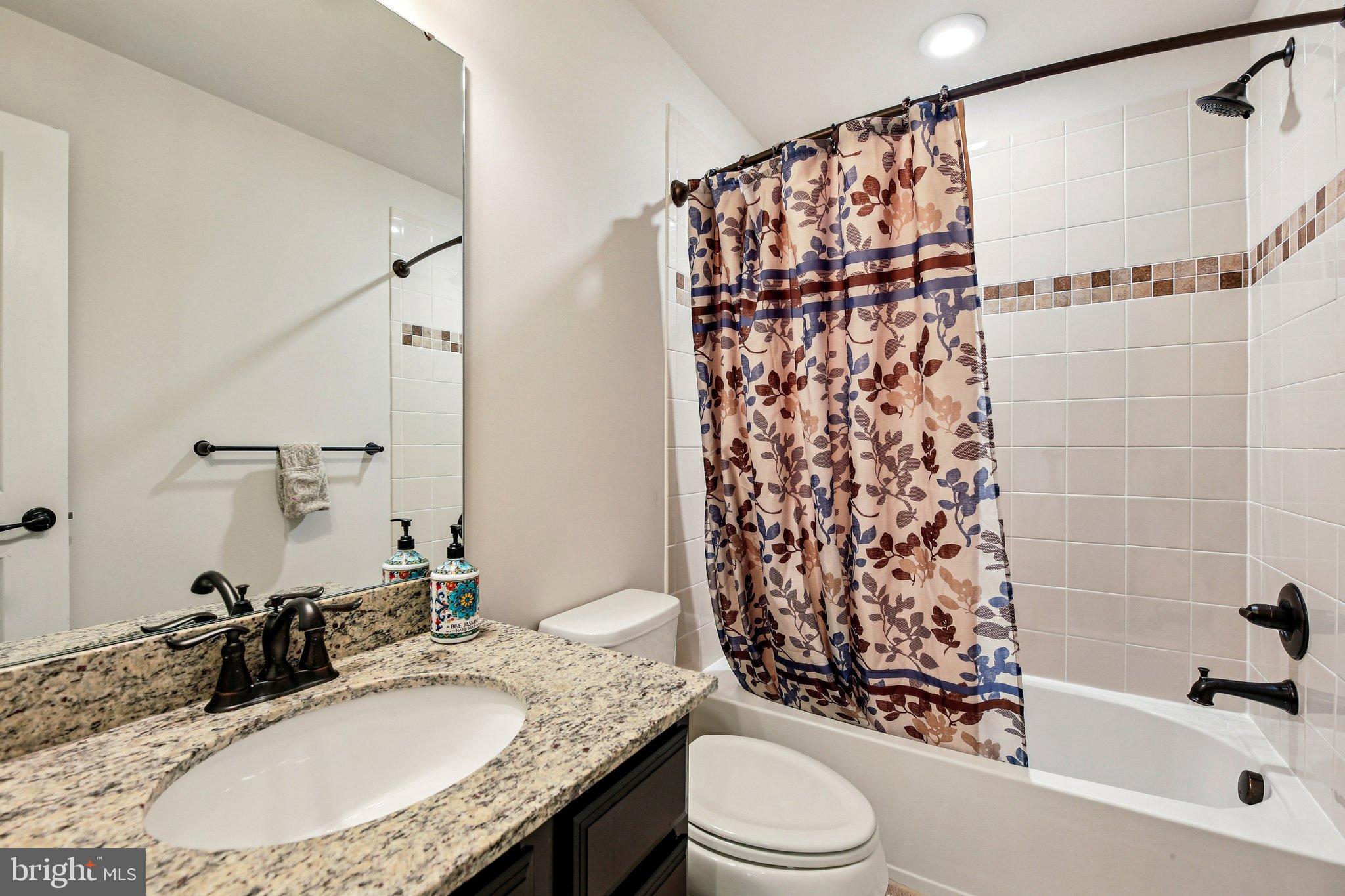 5940 Duvel Street Ijamsville, MD 21754 - Photo 39 of 62 a bathroom with a granite countertop sink toilet and shower