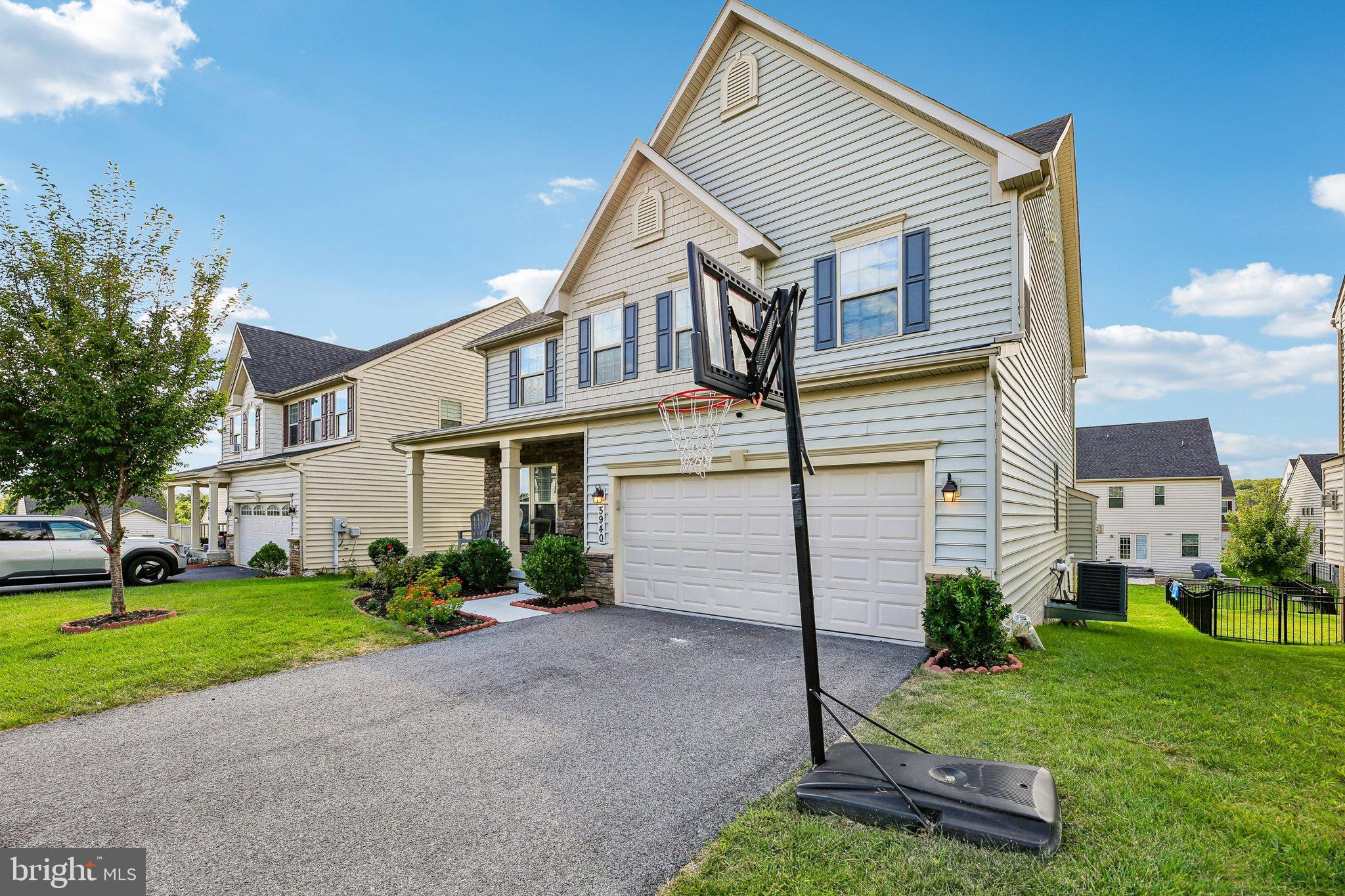 5940 Duvel Street Ijamsville, MD 21754 - Photo 5 of 62 a view of a white house next to a yard with potted plants