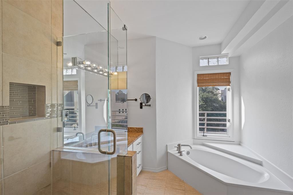 4040 Avondale Avenue, Unit 107 Dallas, TX 75219 - Photo 22 of 33 a bathroom with a granite countertop sink a mirror and shower