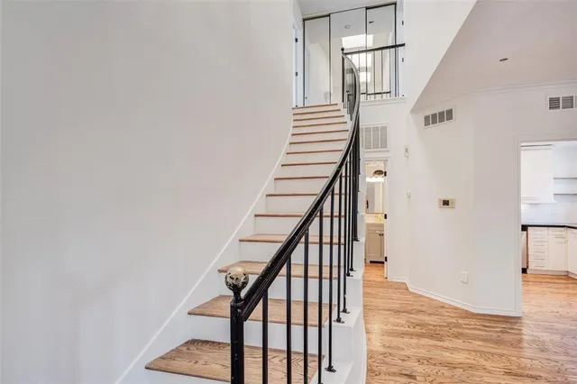 a view of staircase with wooden floor and white walls