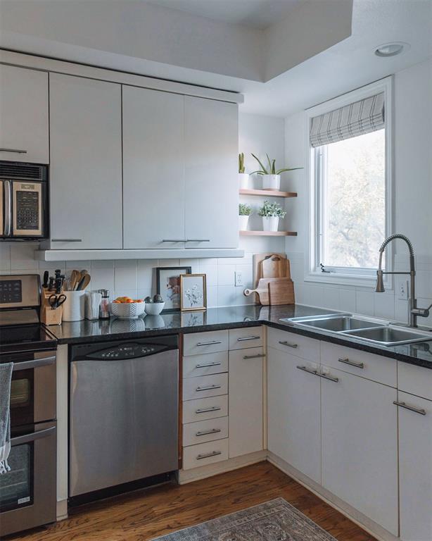 4040 Avondale Avenue, Unit 107 Dallas, TX 75219 - Photo 5 of 33 a kitchen with granite countertop white cabinets and white appliances
