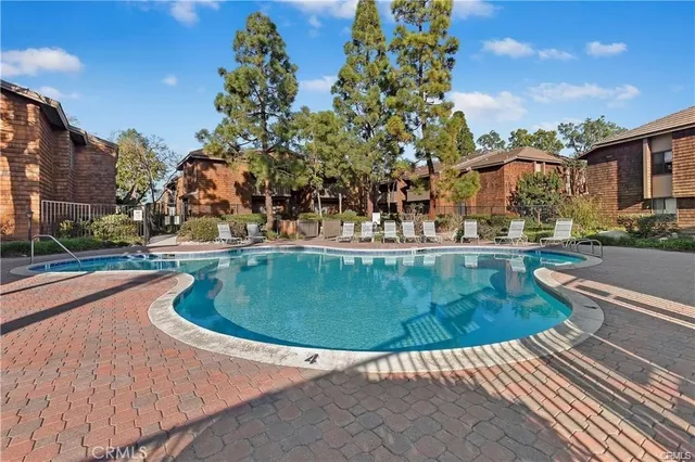 a view of a swimming pool with a yard and plants
