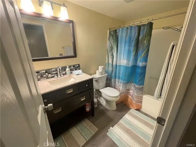 a bathroom with a sink a toilet a mirror and shower