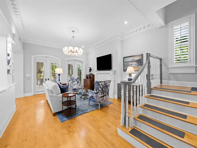 a living room with furniture chandelier and wooden floor