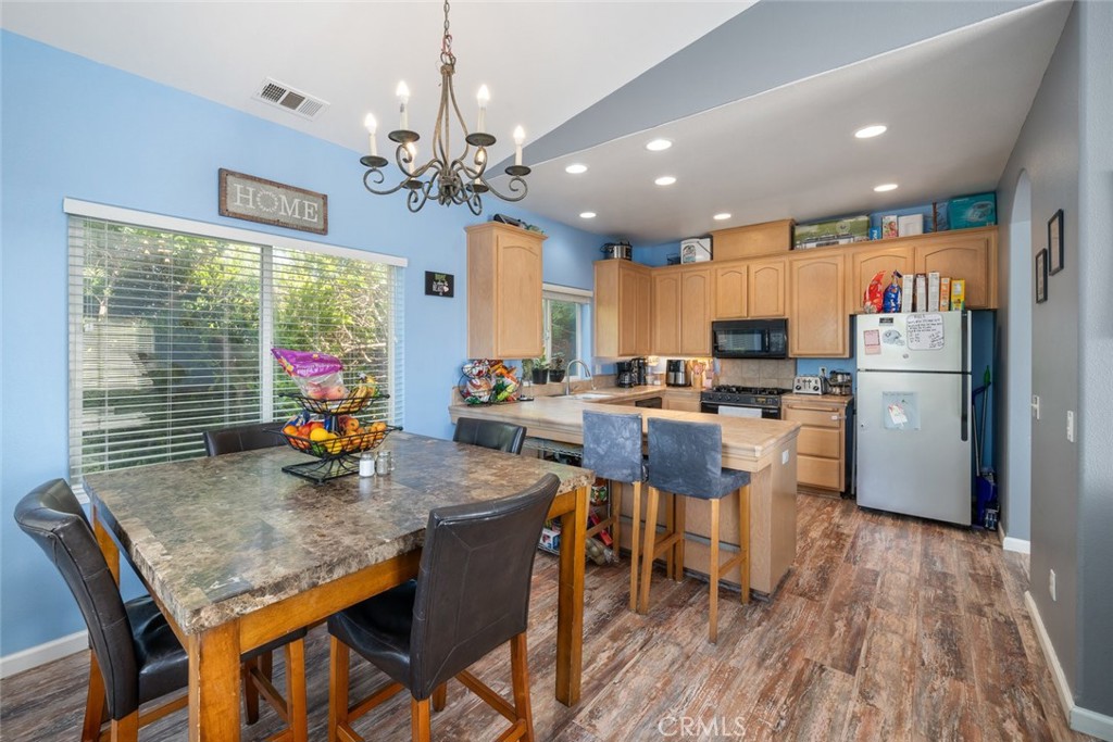 1681 Ocean Street Oceano, CA 93445 - Photo 6 of 25 a kitchen with stainless steel appliances kitchen island granite countertop a refrigerator a stove top oven a dining table and chairs with wooden floor