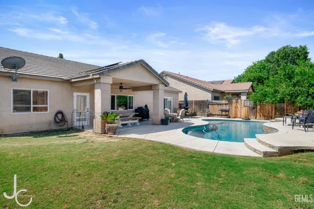 a view of a house with a patio and a yard