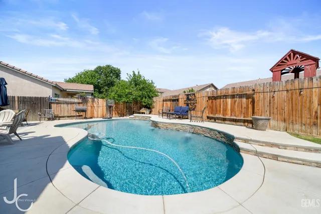 a view of a house with swimming pool and sitting area