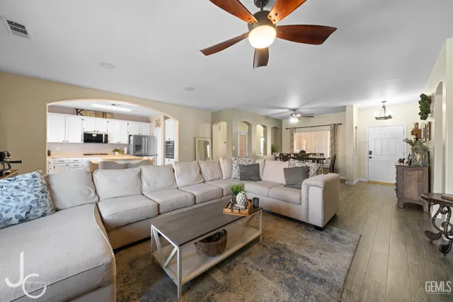 a living room with furniture and a view of kitchen