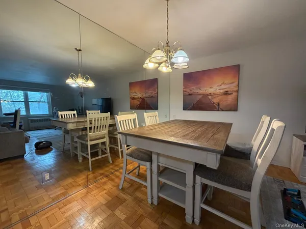 a view of a dining room with furniture a chandelier and wooden floor
