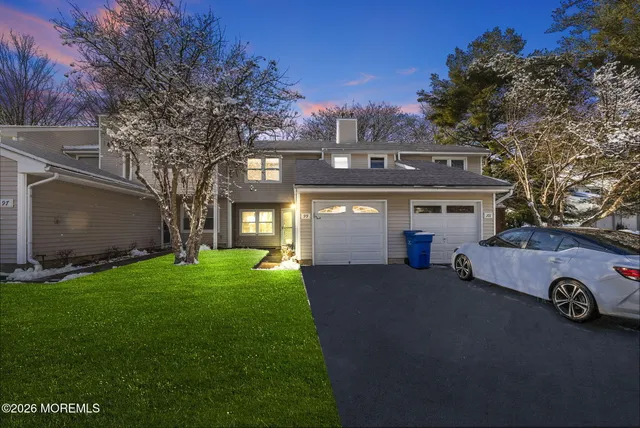 a view of a house with a yard and a garage