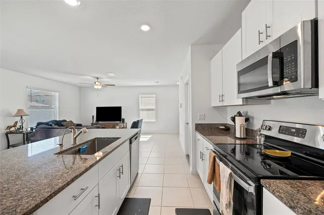a kitchen with stainless steel appliances granite countertop a sink stove and microwave
