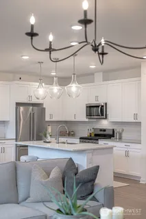 a kitchen with stainless steel appliances granite countertop a sink and a refrigerator