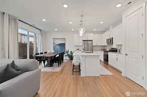 a kitchen with a table chairs a sink a window and stainless steel appliances