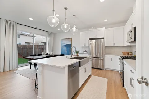a kitchen with stainless steel appliances a stove refrigerator sink and cabinets