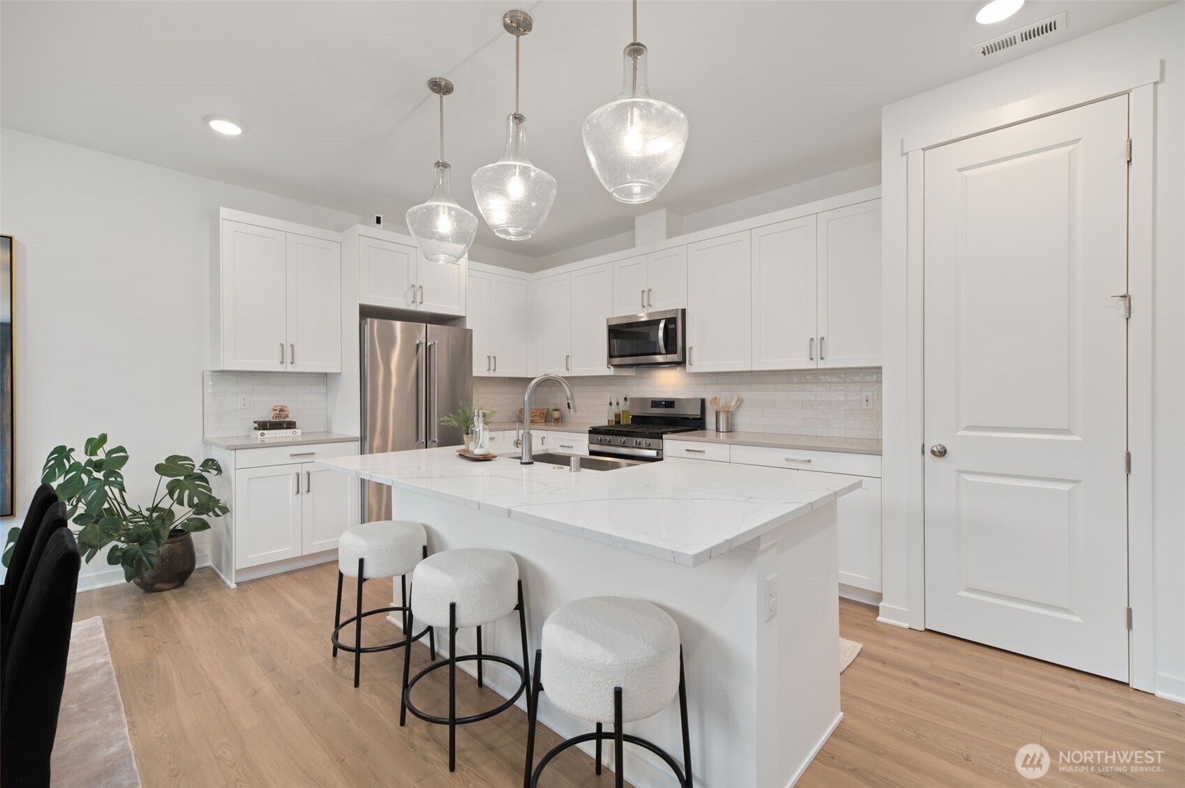 20709 137th Street Southeast Monroe, WA 98272 - Photo 15 of 40 a kitchen with a refrigerator a stove cabinets dining table and chairs