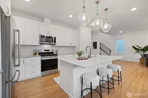 a kitchen with stainless steel appliances a stove a sink island and a refrigerator