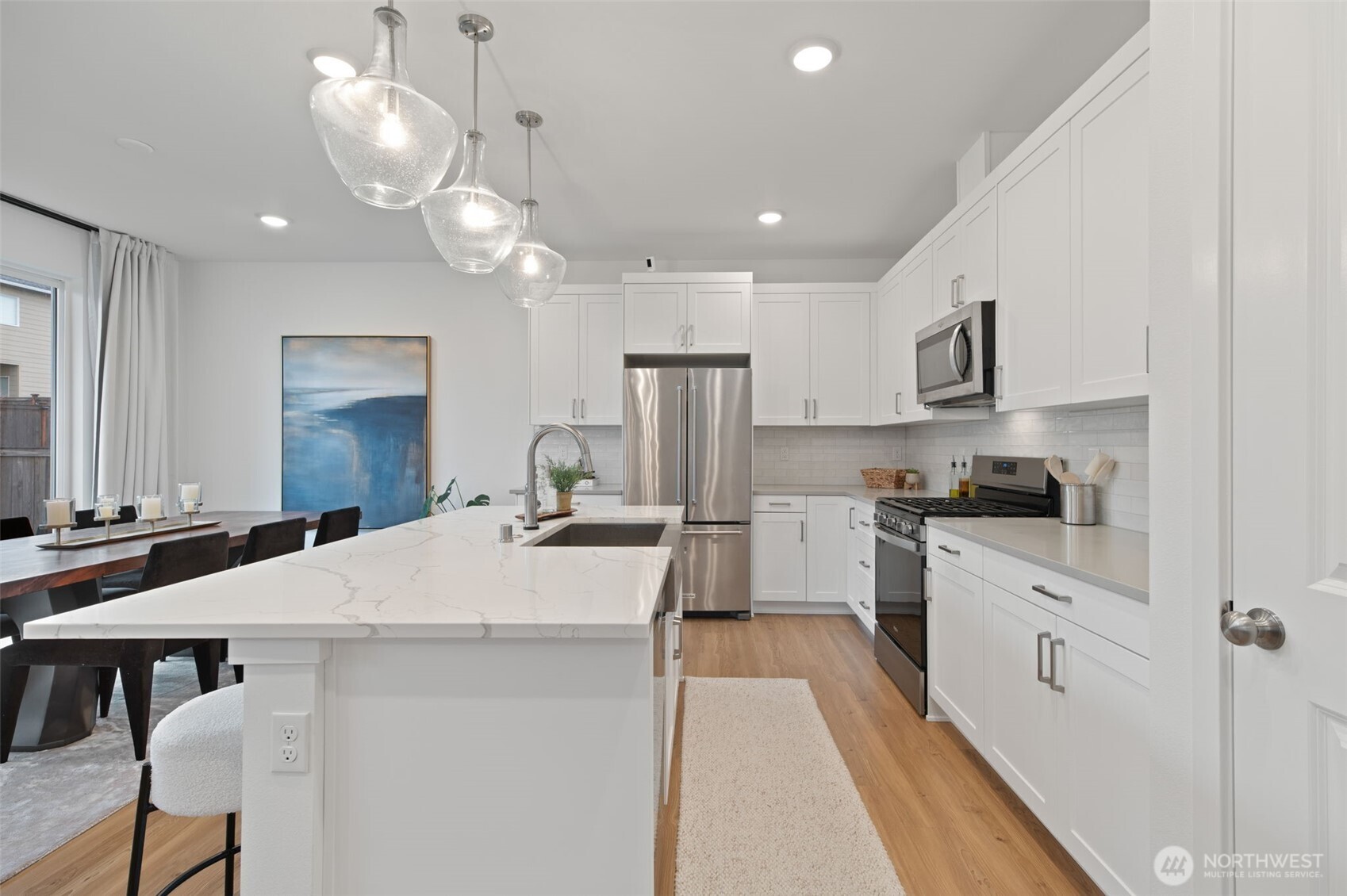 20709 137th Street Southeast Monroe, WA 98272 - Photo 18 of 40 a large kitchen with kitchen island a stove a sink a dining table and chairs