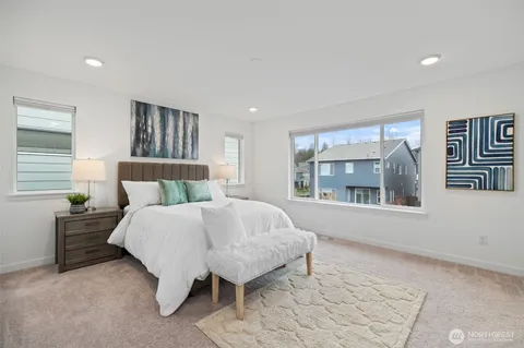 a bedroom with a bed and a large window