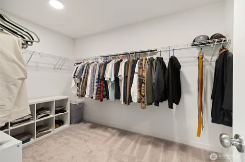 a view of walk in closet with clothes and shoes