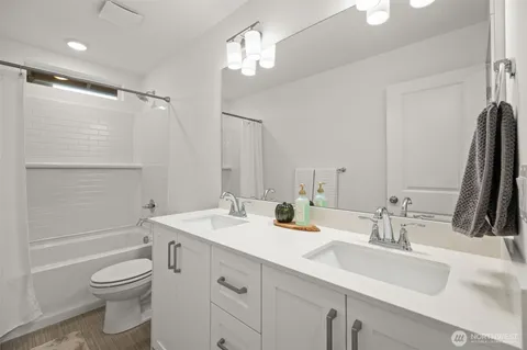 a bathroom with a double vanity sink toilet and shower