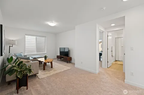 a living room with furniture a potted plant and a flat screen tv