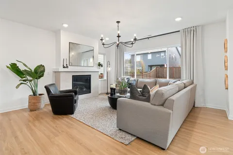 a living room with furniture a fireplace and a chandelier