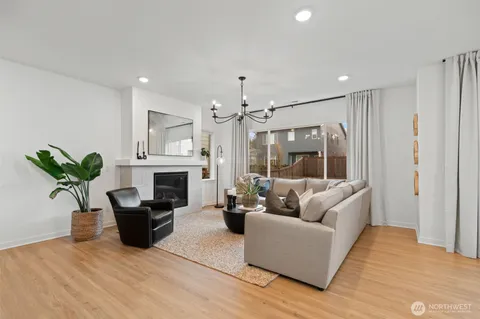 a living room with furniture a fireplace and a chandelier