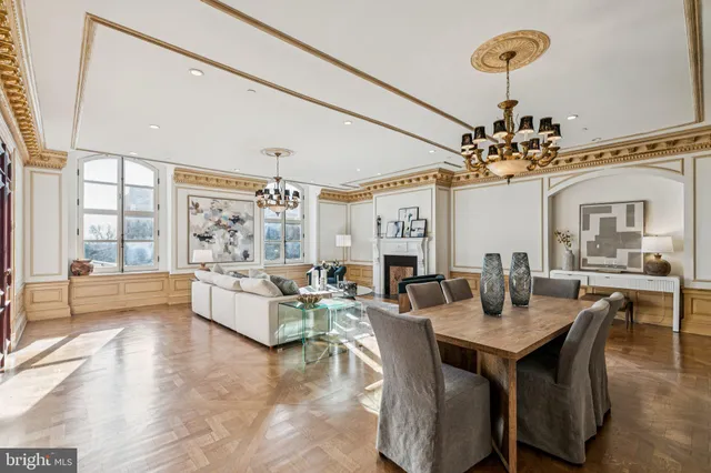a living room with furniture a chandelier and a dining table