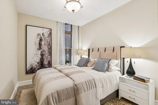 a bedroom with a large bed and a chandelier