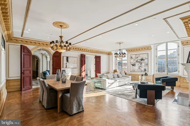 a living room with fireplace furniture and a chandelier