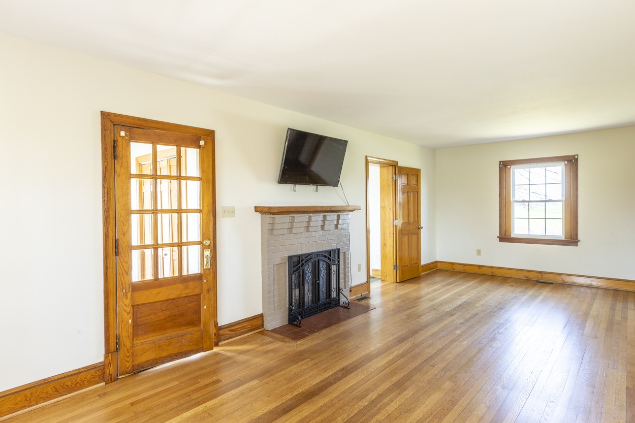713 Battlefield Road Fort Defiance, VA 24437 - Photo 23 of 47 wooden floor fireplace and windows in an empty room