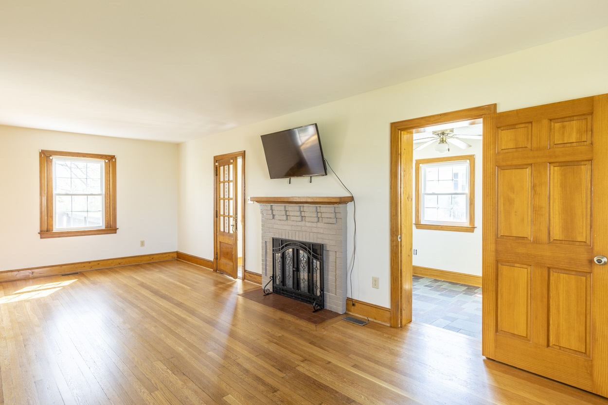713 Battlefield Road Fort Defiance, VA 24437 - Photo 25 of 47 an empty room with wooden floor fireplace and windows
