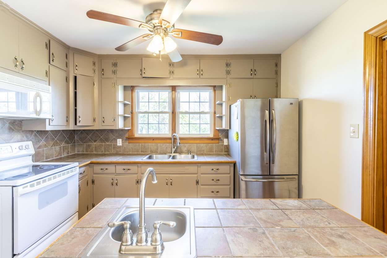 713 Battlefield Road Fort Defiance, VA 24437 - Photo 28 of 47 a kitchen with a sink a refrigerator and cabinets