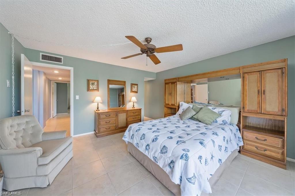 3 Bluebill Avenue, Unit 207 Naples, FL 34108 - Photo 14 of 32 a bedroom with a balcony a bed and a couch