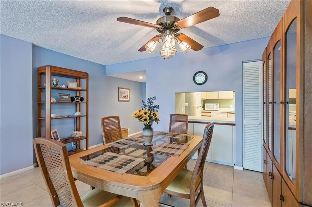 3 Bluebill Avenue, Unit 207 Naples, FL 34108 - Photo 16 of 32 a view of a dining room with furniture and a chandelier
